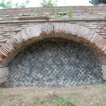 Opus Testaceum arches on travertine corbels, infilled with reticulata in basalt